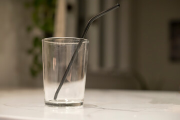 Empty glass with a black straw on a countertop