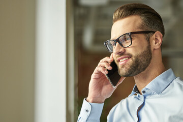 Gladsome handsome man feeling happy at the phone talk