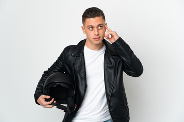 Fototapeta premium Caucasian man with a motorcycle helmet isolated on white background having doubts and thinking