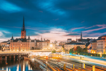 Obraz premium Stockholm, Sweden. Scenic View Of Stockholm Skyline At Summer Sunset. Riddarholm Church And Subway Railway With Train In Blurred Motion