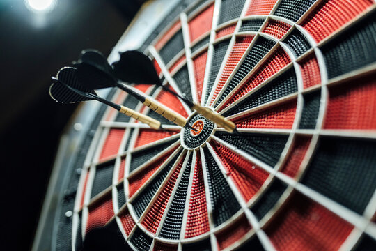 Red and black dartboard with darts