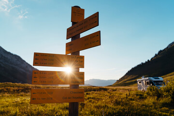 Signs indicating mountain routes with motor home during sunset at Col des Aravis;Haute-Savoie,