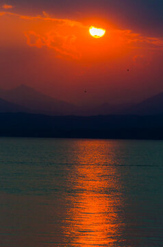 Italy, Province of Verona, Lazise, Lake Garda at red fiery sunset