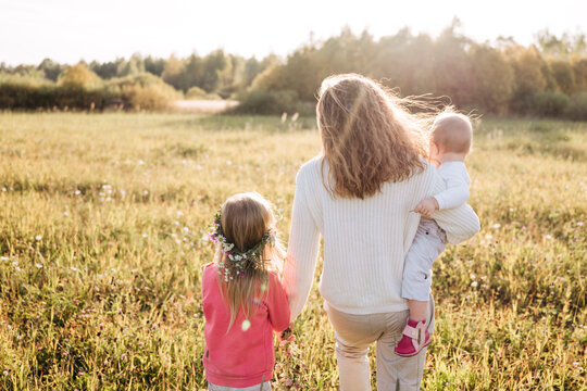 Mother with daughters spending leisure time in agricultural field
