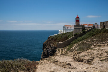 Fototapeta na wymiar Rocky Coastline And Lighthouse At Cabo De Sao Vicente, Algarve, Portugal, Europe