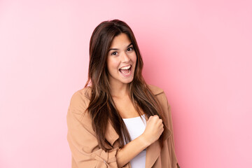 Fototapeta premium Teenager Brazilian girl over isolated pink background celebrating a victory