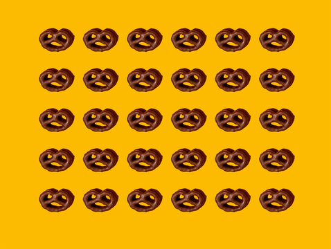 Pattern of chocolate pretzels&not;&dagger;against yellow background