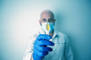 a syringe with a vaccine in a doctor's outstretched hand