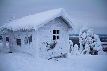 Hidden Santas cottage covered in snow in the ski slopes on the mountain at Levi ski center,...