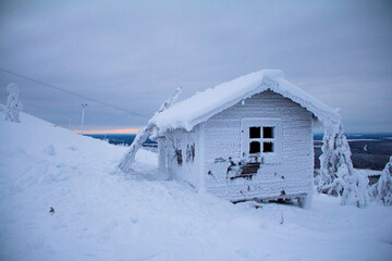 Hidden Santas cottage covered in snow in the ski slopes on the mountain at Levi ski center, Kittilä, Finland.