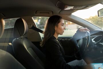Fototapeta na wymiar Young businesswoman looking away while driving car