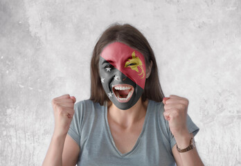 Young woman with painted flag of Papua New Guinea and open mouth looking energetic with fists up