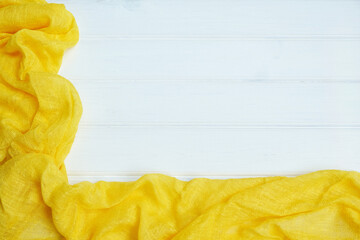 Naklejka premium Tablecloth yellow textile on wooden white background