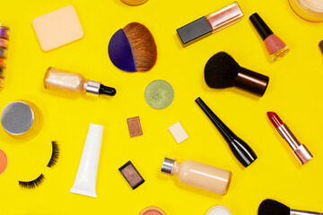 Set of decorative cosmetics on yellow background. Makeup cosmetics tools background