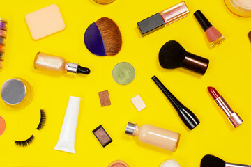 Obraz premium Set of decorative cosmetics on yellow background. Makeup cosmetics tools background