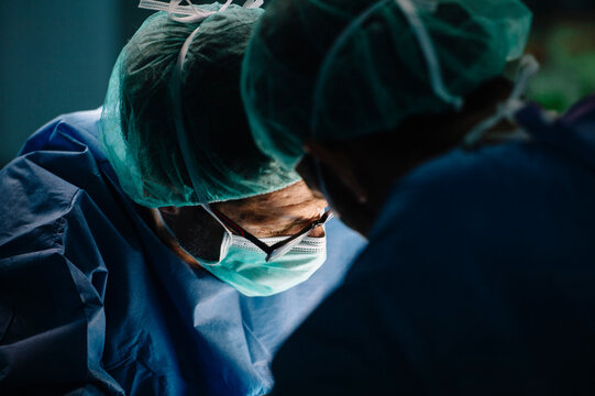 Male orthopedic surgeon with coworker operating surgery in emergency room