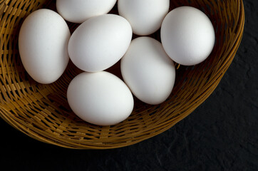 Top View of Fresh White Eggs in a Basket with Dark Background