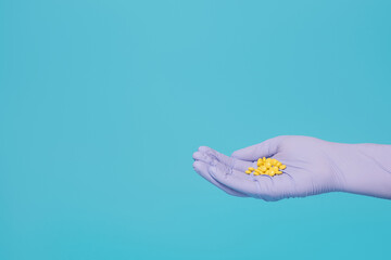 Sedative pills, valerian in hand with blue glove
