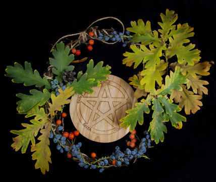 Wiccan pentacle with dried leafs and wreath