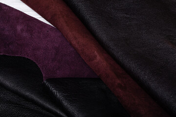 Black dyed with dark brown wrong side natural genuine cow leather folded on a table.