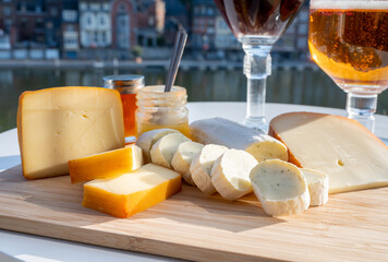 Cheese collection, Belgian abbey cheeses made with brown trappist beer and fine herbs and view on Maas river in Dinant, Wallonia, Belgium