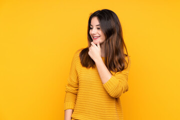 Young caucasian woman isolated on yellow background looking to the side