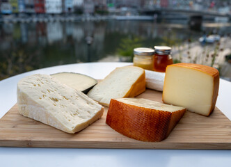 Cheese collection, Belgian abbey cheeses made with brown trappist beer and fine herbs and view on Maas river in Dinant, Wallonia, Belgium