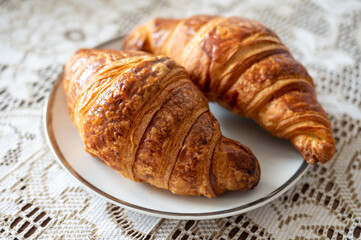 Two fresh baked puff croissants, traditional French breakfast