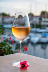 Tasting of local rose wine in summer with sail boats haven of Port Grimaud on background, Provence, France