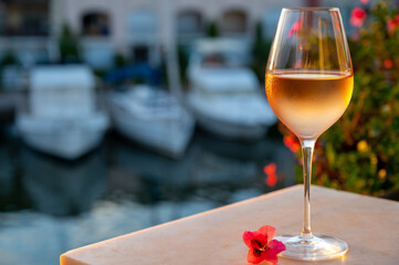 Tasting of local rose wine in summer with sail boats haven of Port Grimaud on background, Provence,...