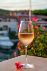 Tasting of local rose wine in summer with sail boats haven of Port Grimaud on background, Provence, France