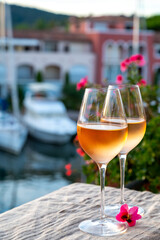 Tasting of local rose wine in summer with sail boats haven of Port Grimaud on background, Provence, France