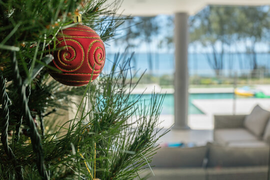 Christmas tree decoration in the summer with pool and lake in background