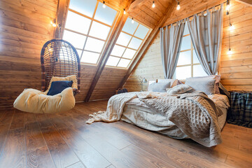 cozy all wooden interior of a country house in a wooden design. spacious living room with kitchen area with large windows. bedroom on the second floor. - obrazy, fototapety, plakaty