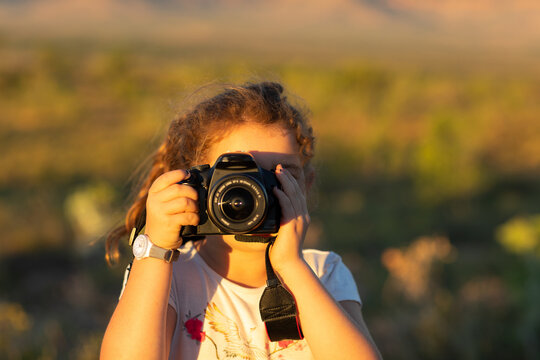 child looking through DSLR camera taking photo of viewer