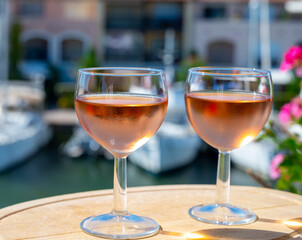Tasting of local rose wine in summer with sail boats haven of Port Grimaud on background, Provence, France