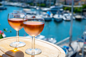 Tasting of local rose wine in summer with sail boats haven of Port Grimaud on background, Provence, France
