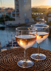 Drinking of local rose wine at sunset with sail boats haven of Port Grimaud on background, Provence, France