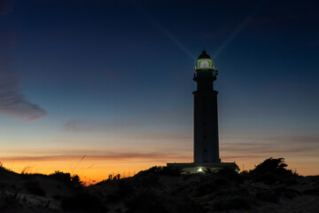Fototapeta na wymiar the Cape Trafalgar lighthouse signal light after sunset with colorful evening sky