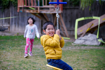 The boy playing zip lining in the backyard 