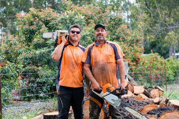 Portrait of two happy aussie blokes with chainsaws - lumberjack tree felling services