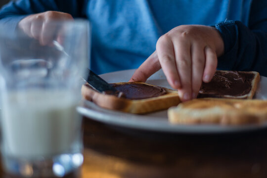 boy eating breakfast, spreading toast
