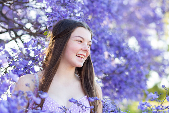 Laughter on the face of young teen girl with purple bokeh background