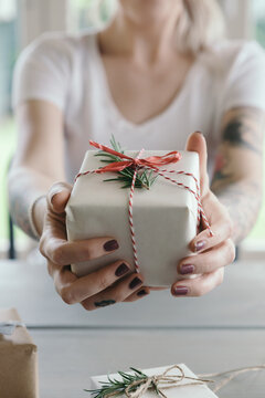 Girl holding gift wrapped christmas present to camera