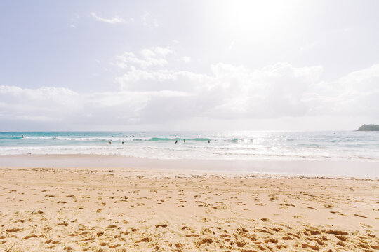 Walked in sand on Bondi Beach and surf with sun flare