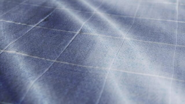 Blue white tablecloth, picnic gingham is waving. Close up macro shot checkered fabric cloth background.