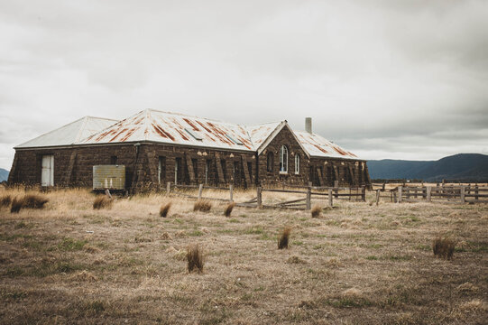 abandoned bluestone shearing shed in the dry grassy landscape