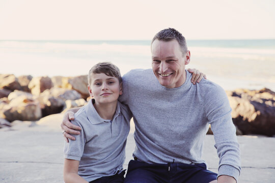 Happy Father And Teen Son On The Beach