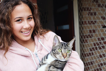 Happy multicultural teen holding cat