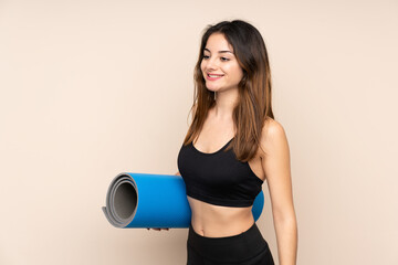 Young sport woman with mat over isolated background